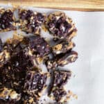 dates covered in peanut butter, peanuts, chocolate and sea salt cut into bite size pieces