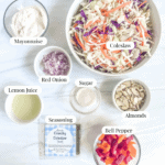 Ingredient picture with a bowl of mayonnaise, bowl of lemon juice, bowl of sugar, bowl of almonds, bowl of chopped bell pepper, bowl of coleslaw, seasoning packet