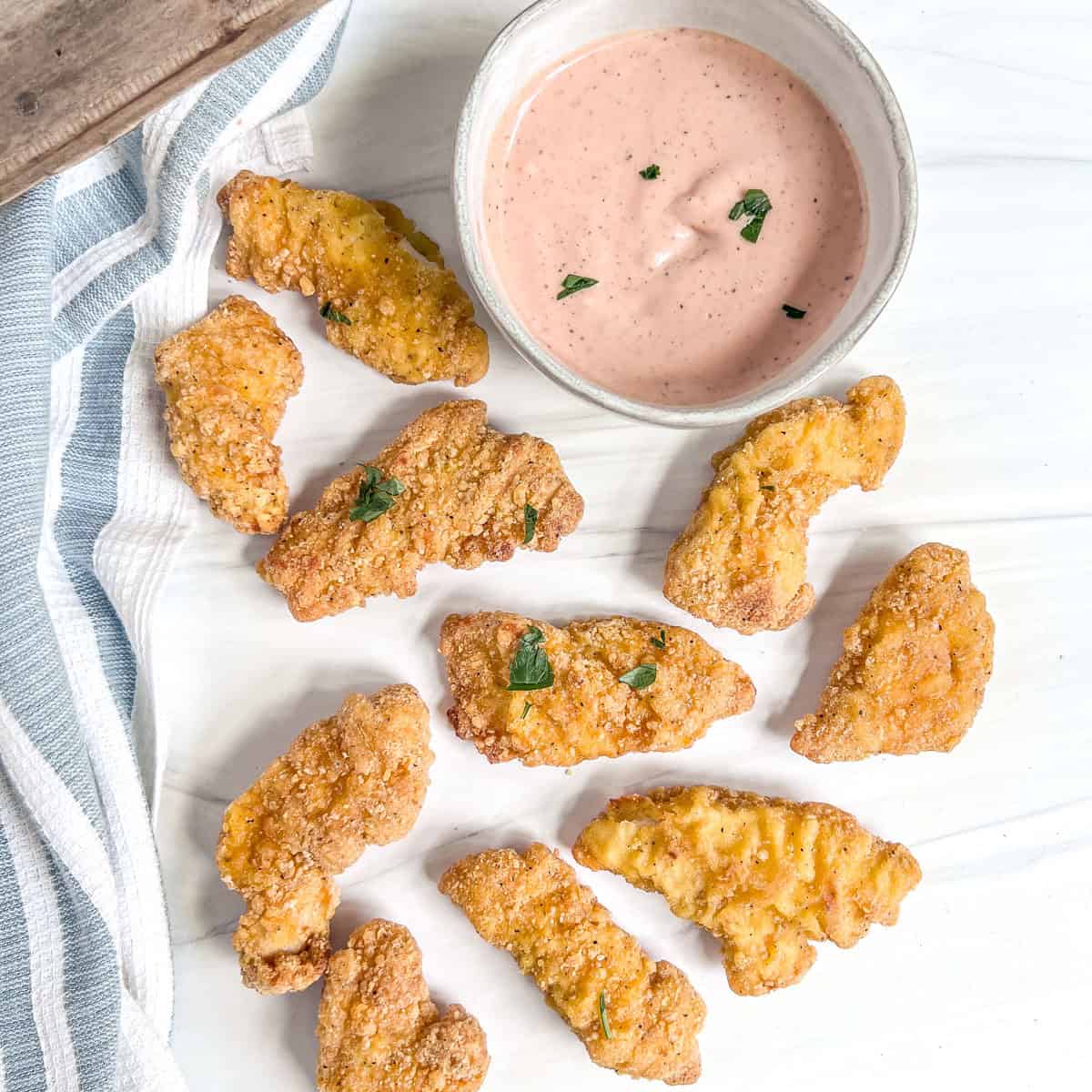chicken tenders and a bowl of chicken dipping sauce