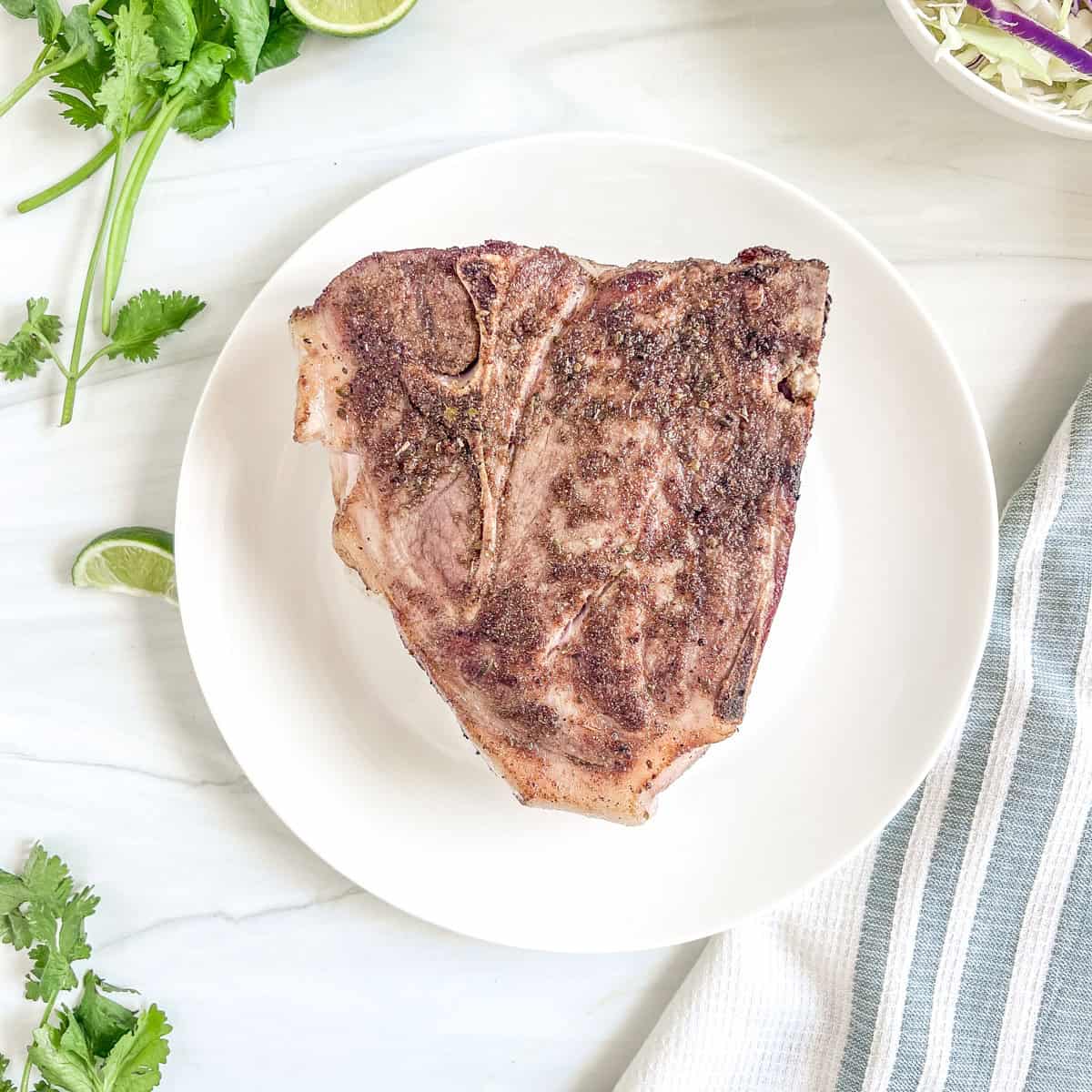 pork roast seared on the sides with fresh cilantro and lime slices to the side