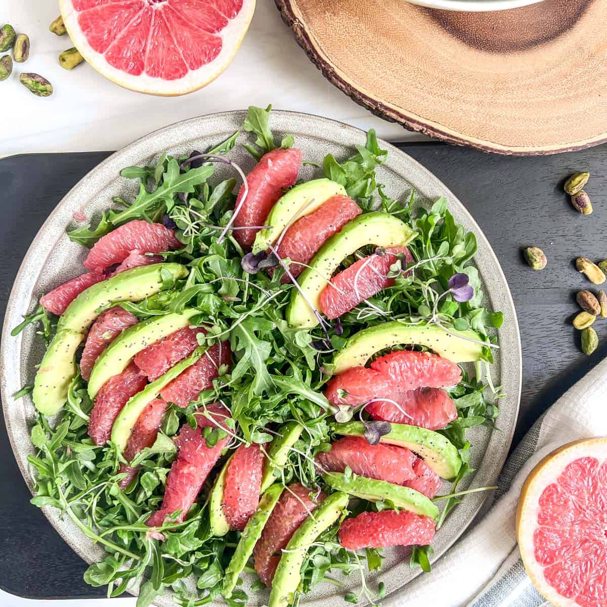 plate of avocado and grapefruit slices with lettue under the slices