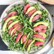 plate of slices of grapefruit and avocado slices on a bed of lettuce