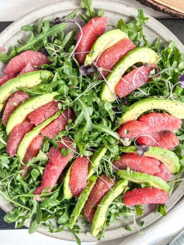 plate of slices of grapefruit and avocado slices on a bed of lettuce