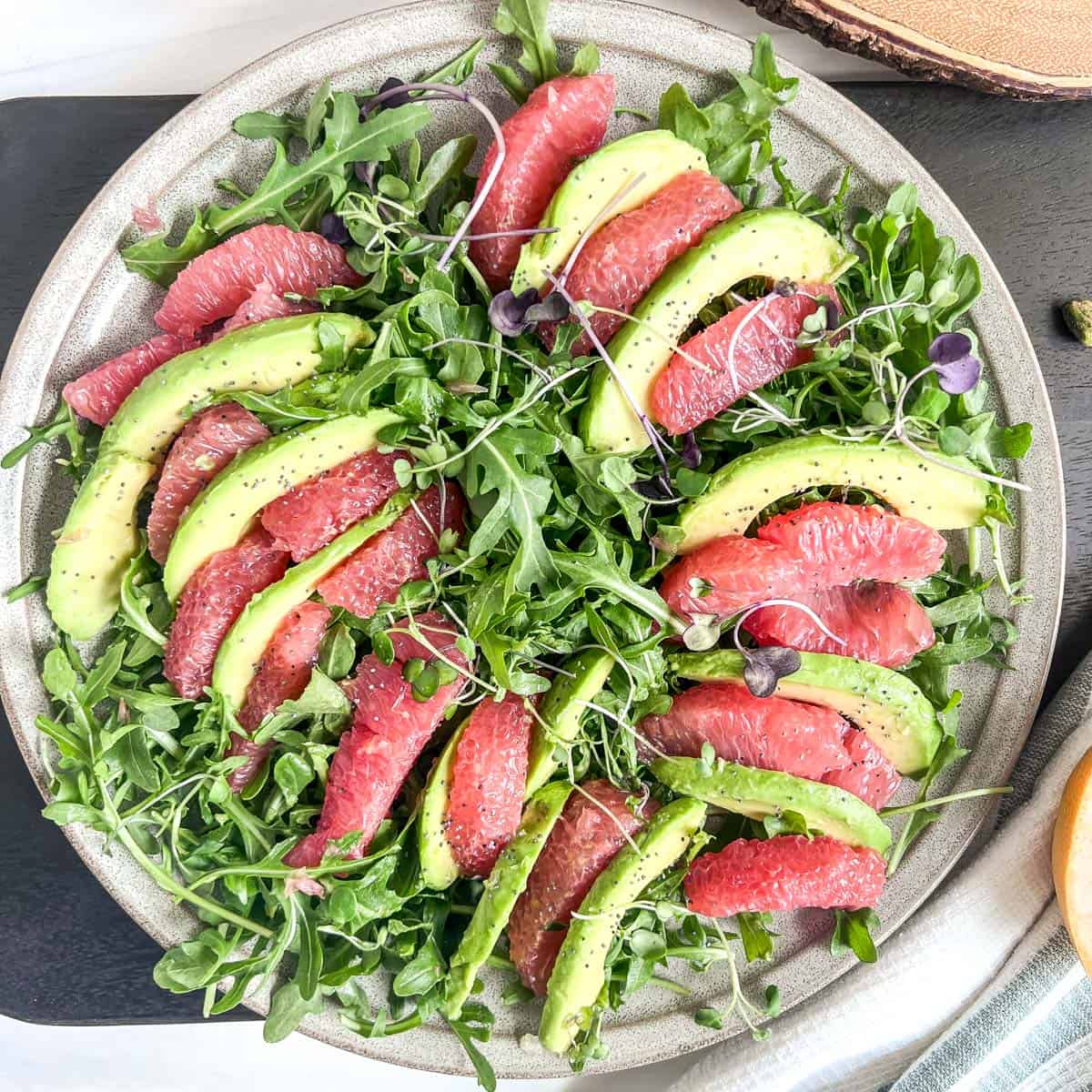 plate of slices of grapefruit and avocado slices on a bed of lettuce