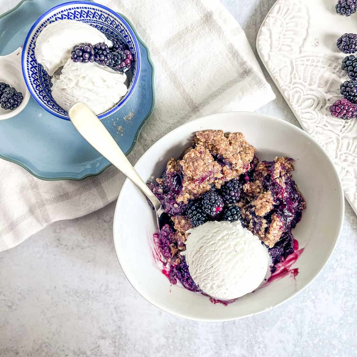 Blackberry Cobbler in a bowl with gold spoon