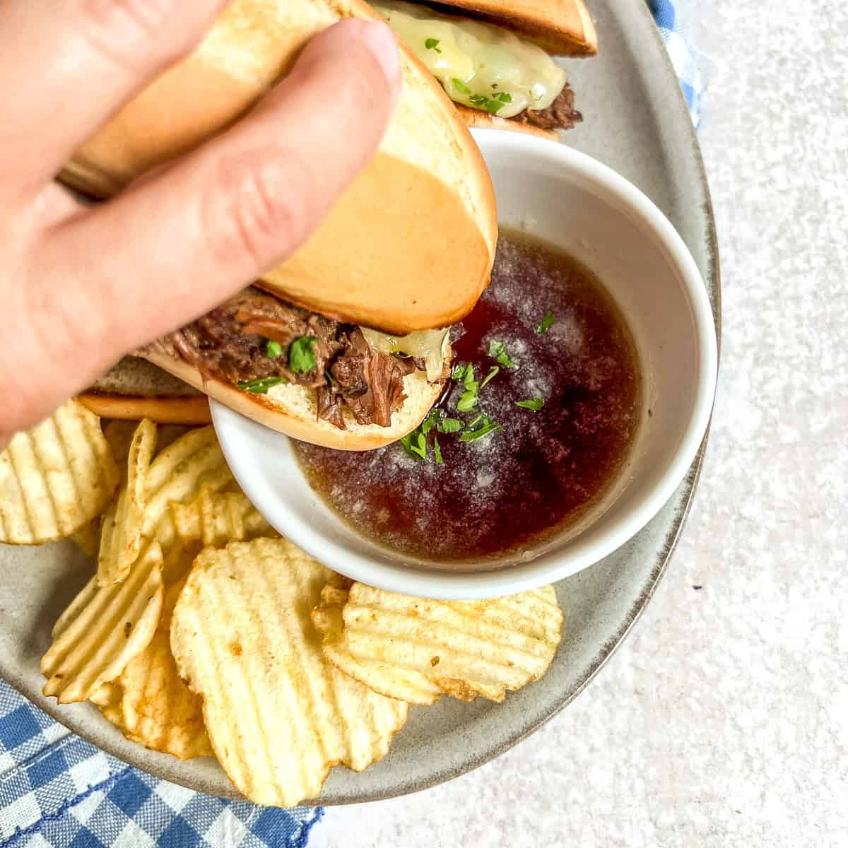 Slow Cooker Pot roast french dip sandwich dipped in beef juice