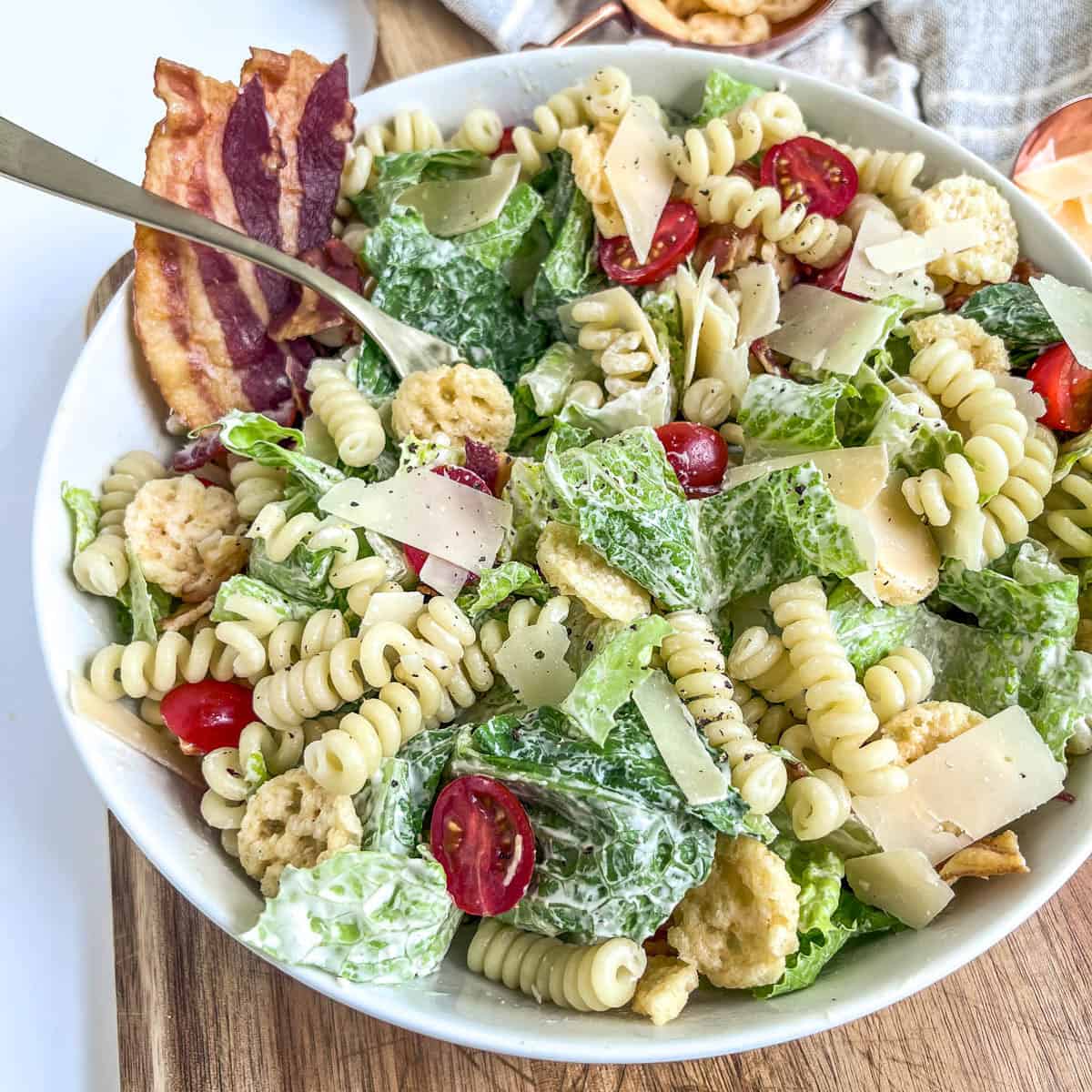 caesar pasta salad side view with a gold fork
