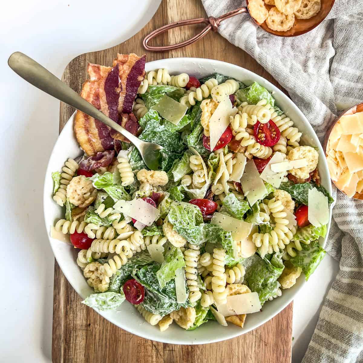 caesar pasta salad with a gold fork in the bowl