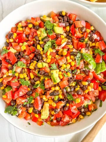 black bean & corn salsa tossed in a white bowl