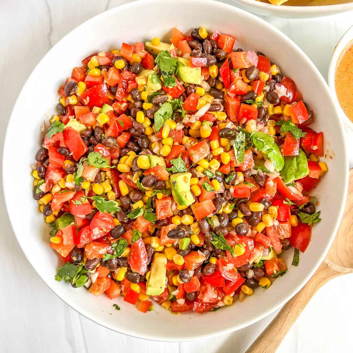 black bean & corn salsa tossed in a white bowl