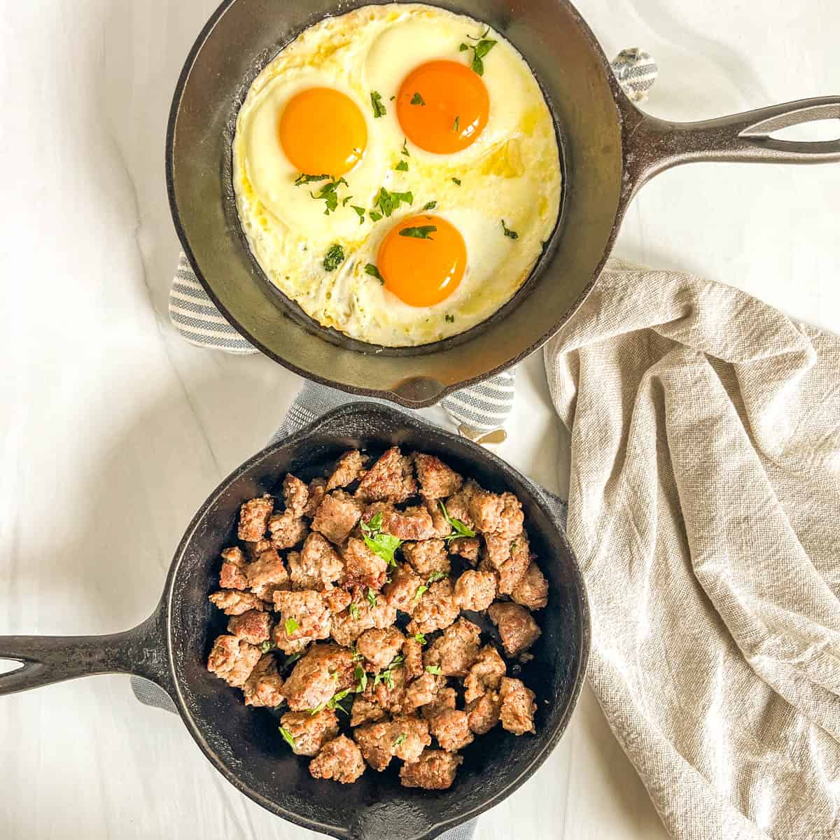 Fall Breakfast Hash fried eggs in a skillet and cooked sausage in a skillet