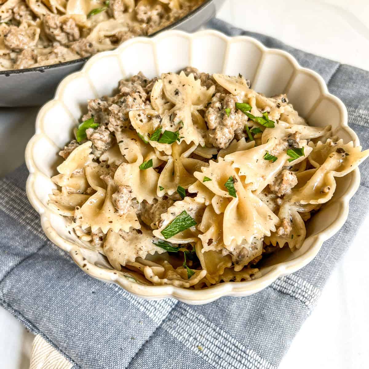 Creamy beef and mushroom farfalle pasta in a decorative bowl.