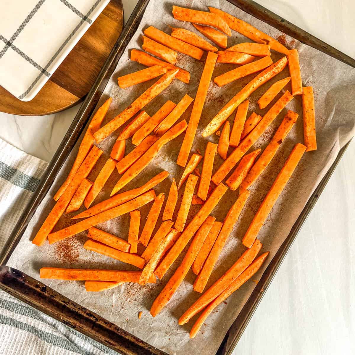 cut up sweet potato fries on a baking sheet