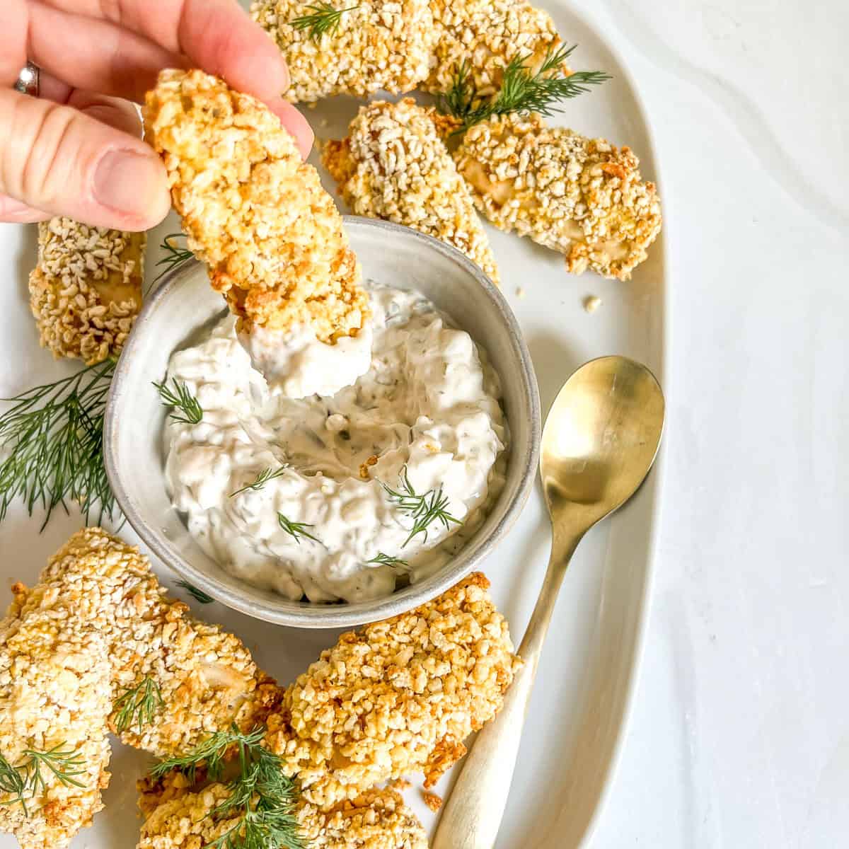 fish stick dipped in tartar sauce