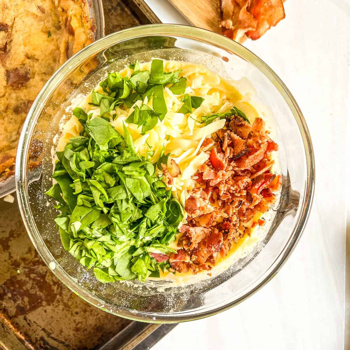 chopped spinach, shredded cheese, chopped bacon in a bowl