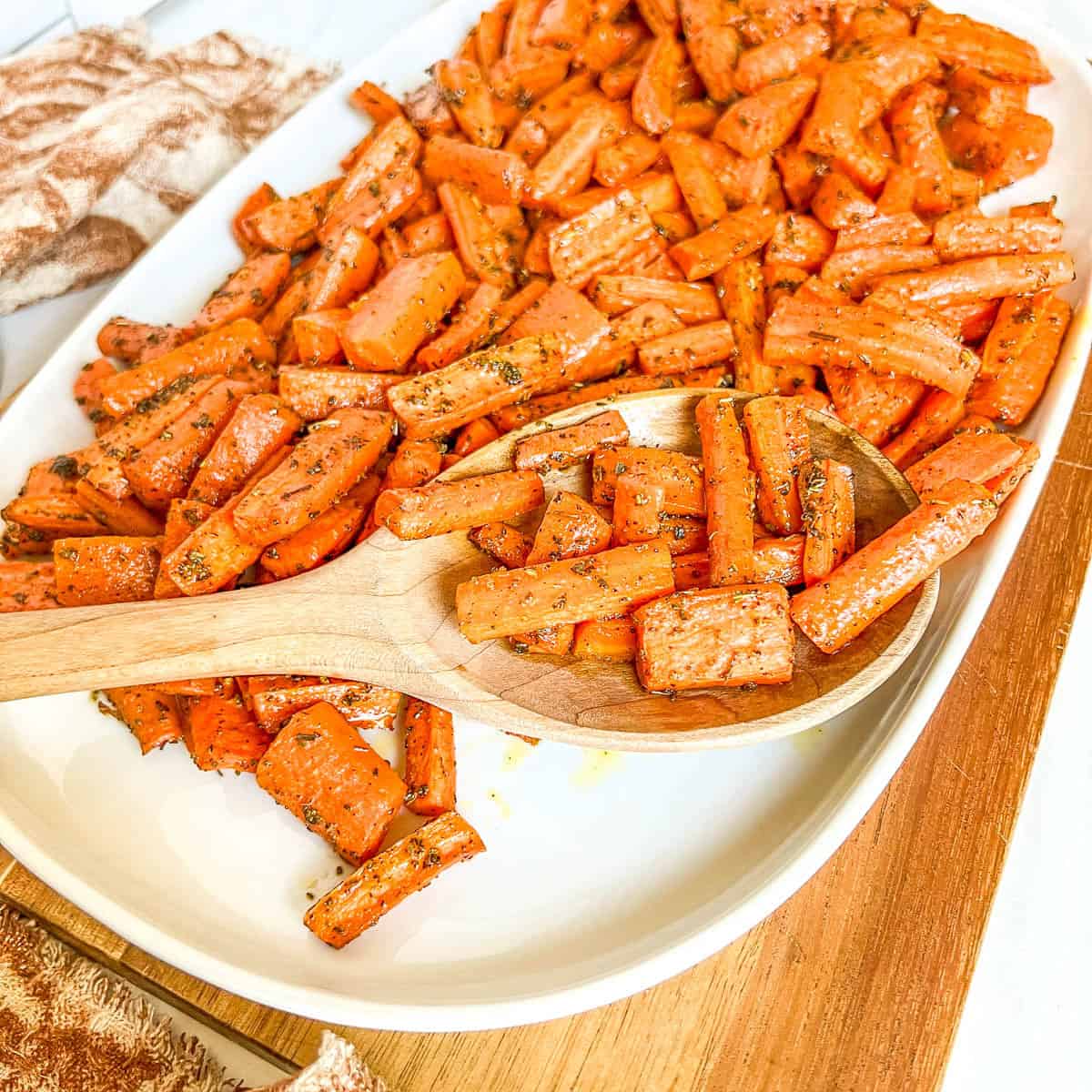 oven roasted carrots on platter with wooden spoon