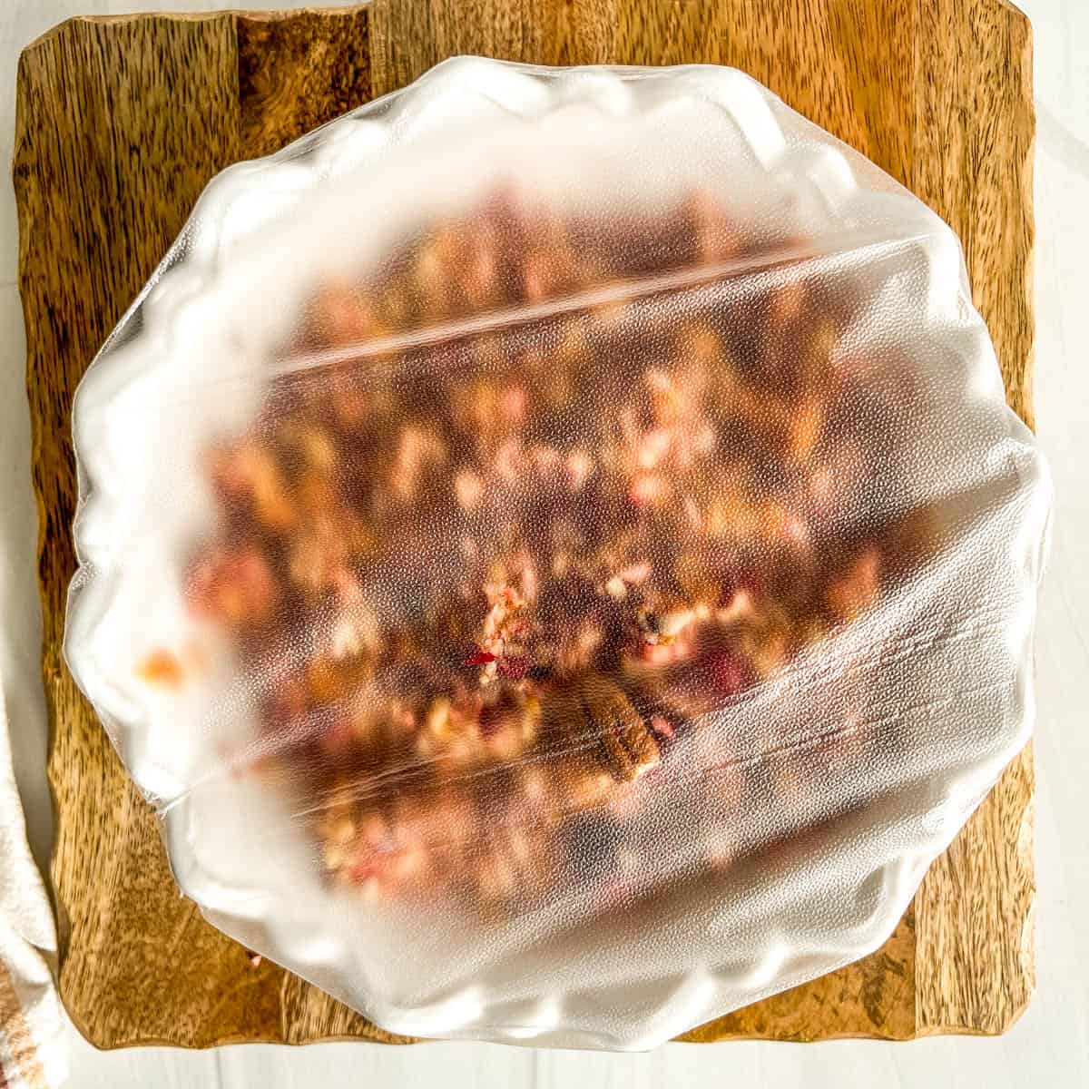 plastic wrap covered bowl of fruit relish