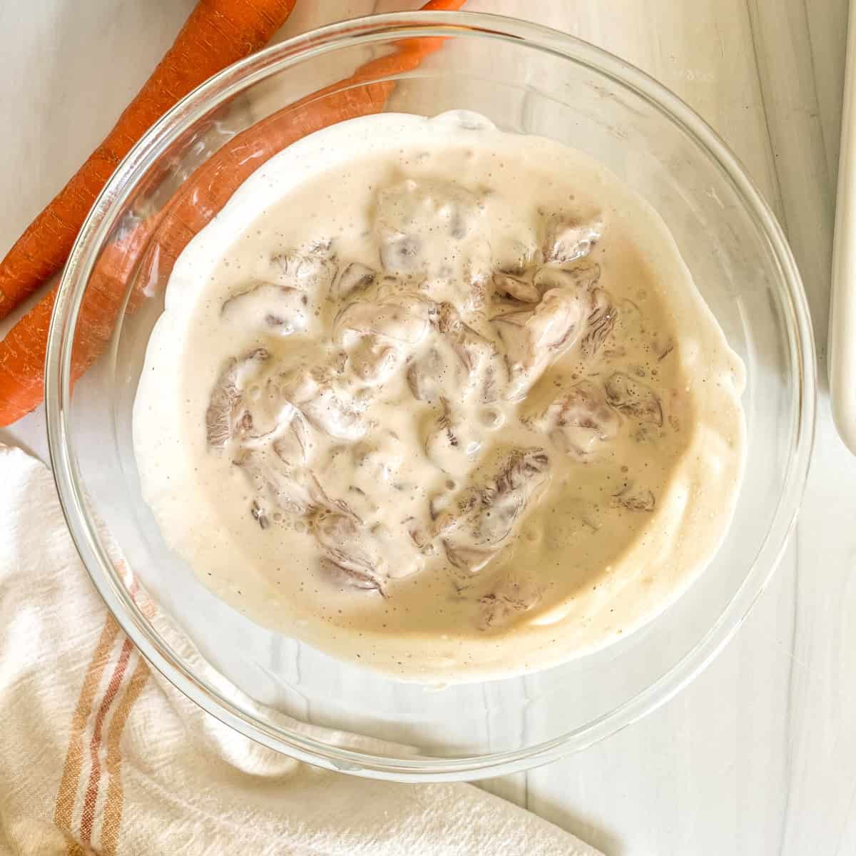 raw chicken marinating in caesar dressing