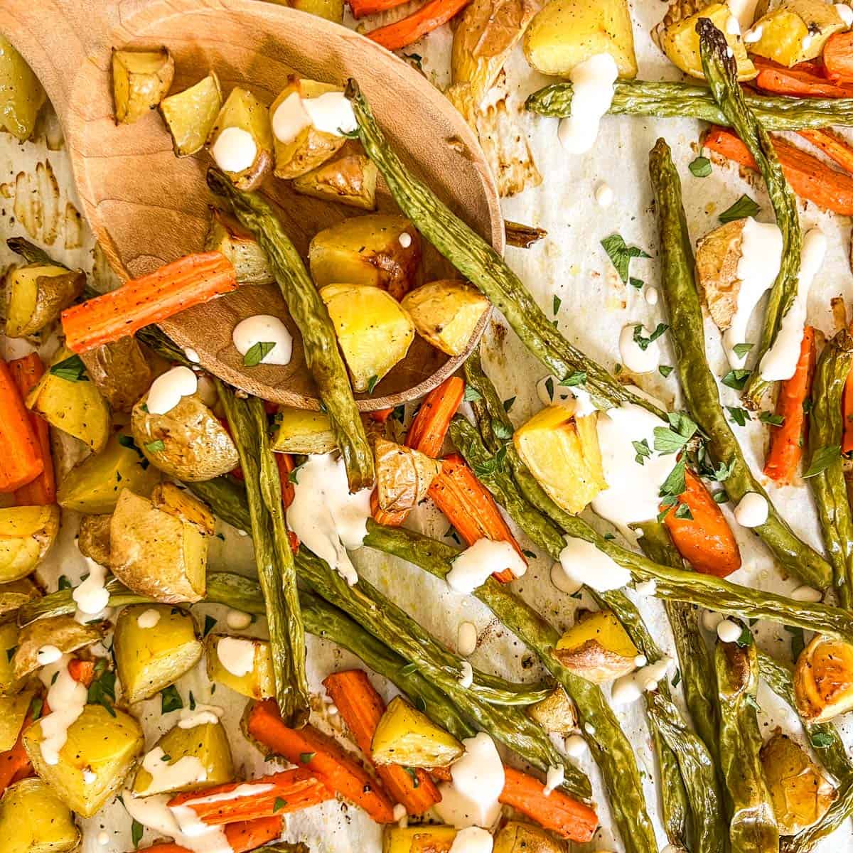 sheet pan vegetables with caesar dressing drizzled on them