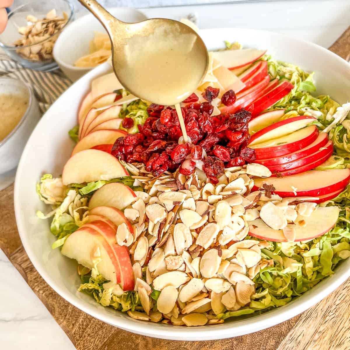 harvest salad in a white bowl with dressing