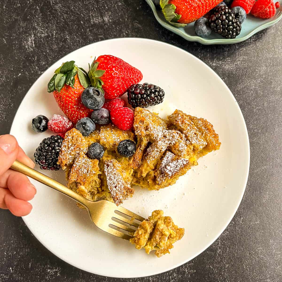 baked french toast on a white plate with gold fork