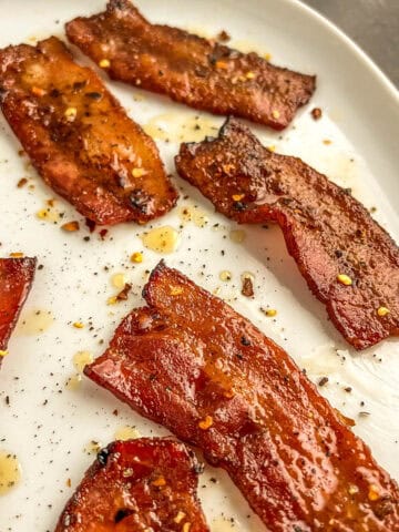 seasoned cooked bacon on a white plate