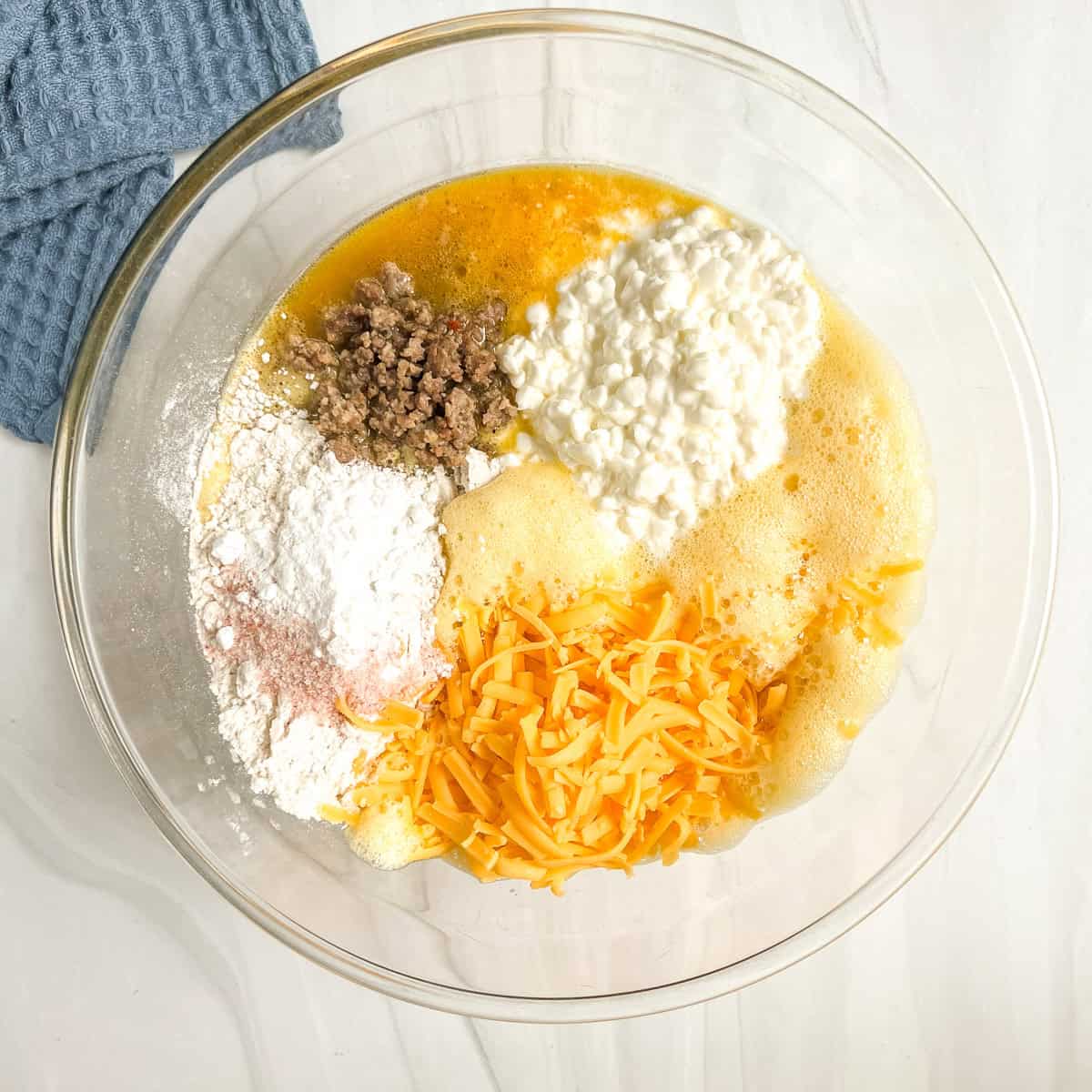 egg casserole ingredients in a glass bowl