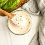 caesar salad dressing with wood spoon in jar
