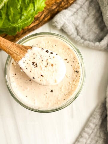 caesar salad dressing with wood spoon in jar